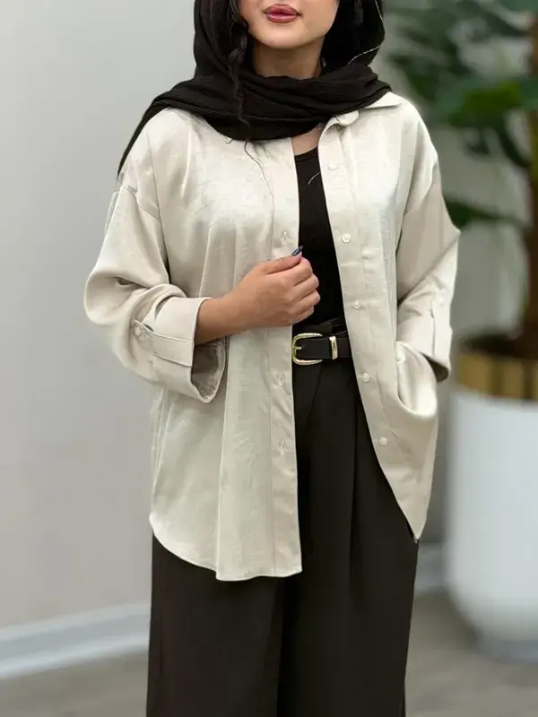 نمای روبه‌روی شومیز وارداتی زنانه رنگ استخوانی با پارچه پری ریزشی، یقه کلاسیک، تنخور آزاد و دوخت باکیفیت.